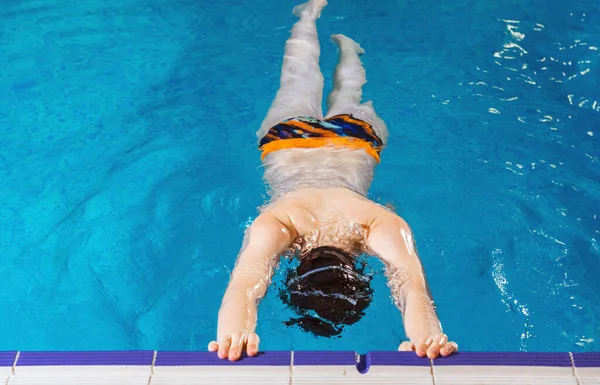 Preteen boy swimming and training in pool — Stockfoto