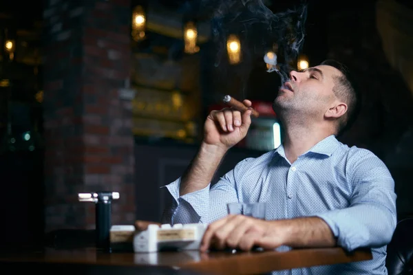 Portrait of hansome man smoking cigar in a lounge bar — Stock Photo, Image