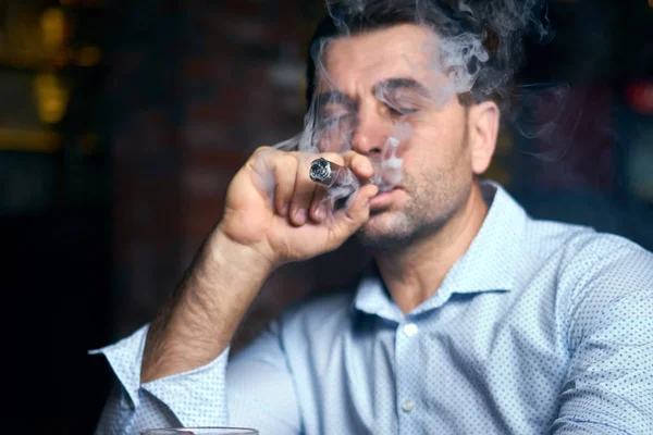 Portrait of hansome man smoking cigar in a lunge bar — Stock Photo, Image