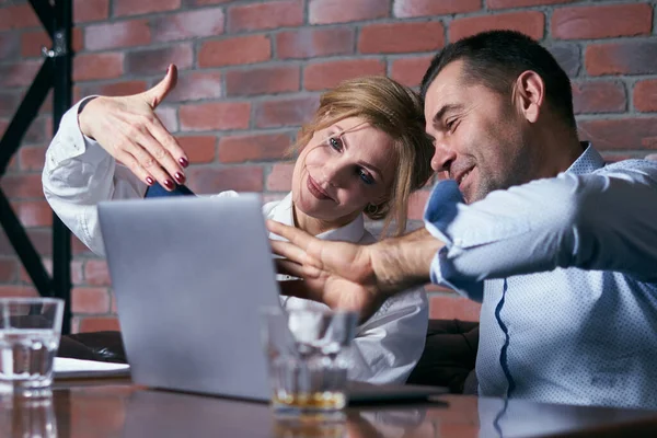 Felice coppia d'affari che lavora insieme sul computer portatile in un ristorante — Foto Stock