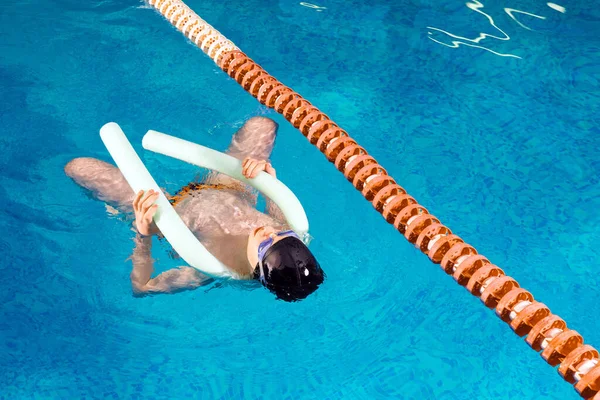 Preteen boy swimming and training in pool — Stockfoto