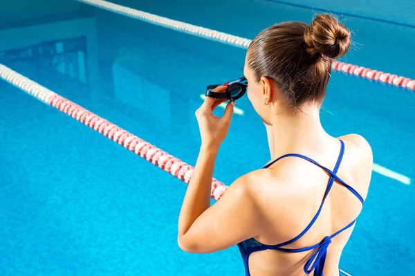Jonge vrouw in het zwembad met een bril klaar om te zwemmen — Stockfoto