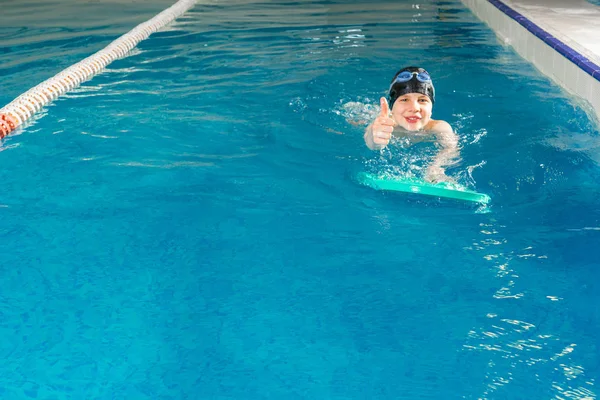 Nastoletni chłopiec pływanie w krytym basenie podczas lekcji pływania — Zdjęcie stockowe