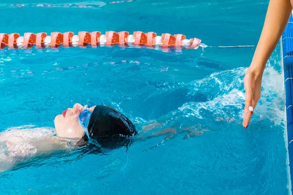 Entrenador femenino en el agua que da la lección de natación del niño preadolescente en la piscina cubierta —  Fotos de Stock