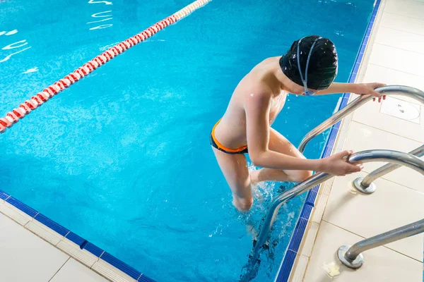 Nastoletni chłopiec pływanie w krytym basenie podczas lekcji pływania — Zdjęcie stockowe