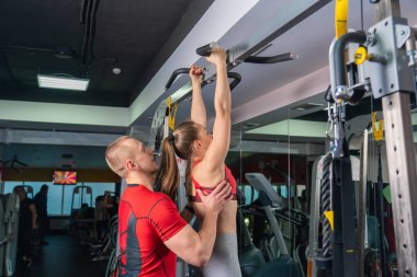Modern spor salonunda genç bir kadınla çalışan özel antrenör.