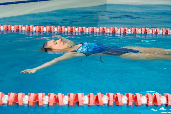 Young professional swimmer woman swimming in indoor pool — Stock Photo, Image