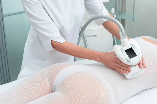 Mulher de terno branco especial recebendo massagem anti-celulite em um salão de spa. GPL, e tratamento de contorno corporal na clínica. — Fotografia de Stock