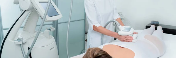 Žena ve speciálním bílém obleku na masáž proti celulitidě v lázeňském salonu. LPG a ošetření kontur těla na klinice. — Stock fotografie