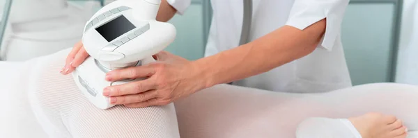 Žena ve speciálním bílém obleku na masáž nohou proti celulitidě v lázeňském salonu. Lpg, a péče o kontury těla na klinice. — Stock fotografie