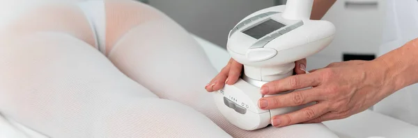 Femme en costume blanc spécial obtenir massage anti-cellulite pour les jambes dans un salon de spa. GPL et traitement de contouring corporel en clinique . — Photo