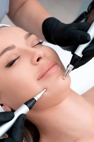Kosmetologii. Piękna kobieta w spa Clinic odbieranie stymulowanie elektryczne leczenie twarzy od terapeuty. Zbliżenie młoda kobieta twarz podczas Microcurrent Therapy — Zdjęcie stockowe