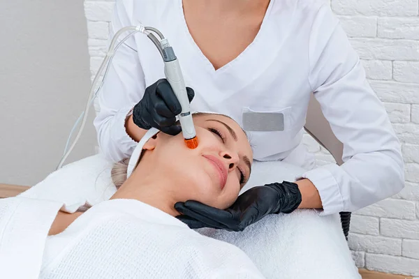 Pielęgnacja Twarzy. zbliżenie kobiety oczyszczanie twarzy w klinice kosmetologii, odkurzanie — Zdjęcie stockowe
