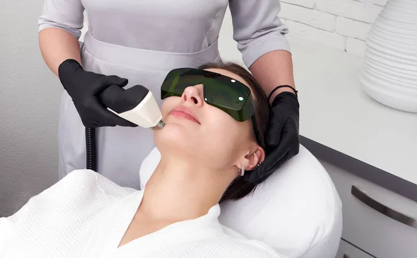 Młoda kobieta leczona laserowo w klinice kosmetologii — Zdjęcie stockowe