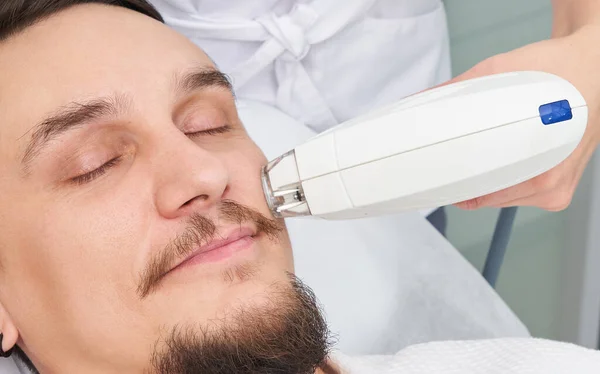 Man Having Laser Treatment At Beauty Clinic