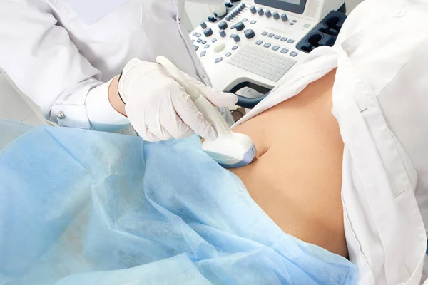Cropped view of pregnant woman undergoing ultrasound test at gynecologist office — Stock Photo, Image
