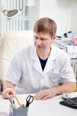 Doktorun bir hastaya danışma sırasında not defterine yazma görüntüsü
