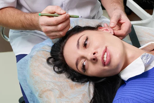 Plastic surgeon examines ear of patient before plastic surgery — Stock Photo, Image