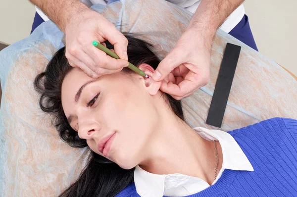 Cirurgião plástico examina orelha do paciente antes da cirurgia plástica — Fotografia de Stock