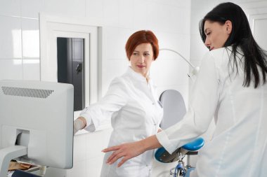 Gynecologist ready to do transvaginal ultrasound with wand and exam a woman clipart