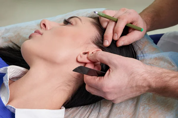 Cirujano plástico examina el oído del paciente antes de la cirugía plástica —  Fotos de Stock
