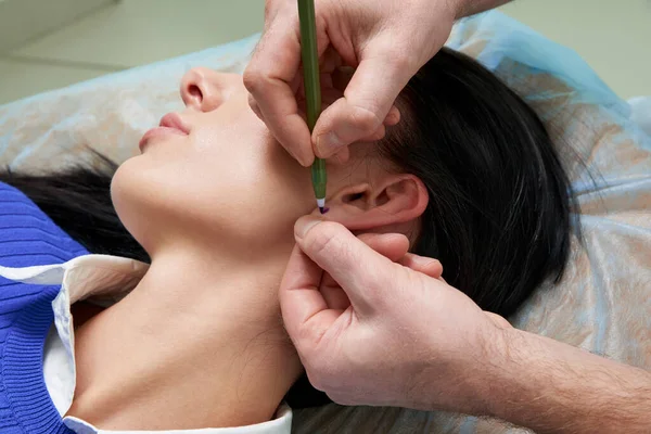 Plastic surgeon examines ear of patient before plastic surgery — Stock Photo, Image