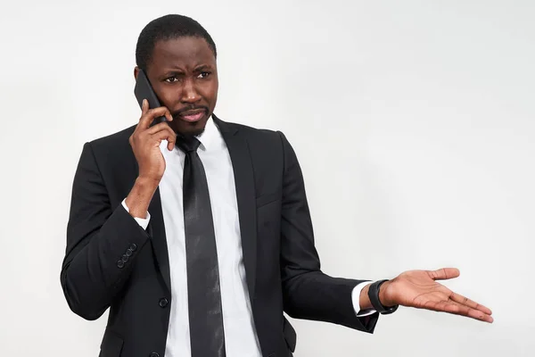 Närbild av arg ung afrikansk man skriker när man talar på smartphone över grå bakgrund — Stockfoto