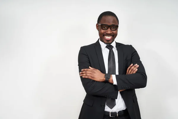 Empresário afro-americano em pé sobre fundo branco rosto feliz sorrindo com braços cruzados olhando para a câmera. Pessoa positiva . — Fotografia de Stock