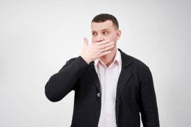 Elleriyle ağzını kapatmış, afallamış ve nutku tutulmuş bir insan portresi.