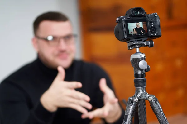 Hombre filmando video blog en cámara con trípode para seguidores en línea. En las redes sociales, Influencer, nuevas tecnologías y concepto de internet — Foto de Stock