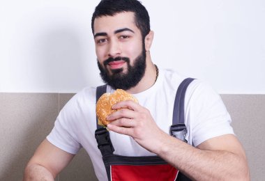 Worker wearing uniform eating burger during lunch break