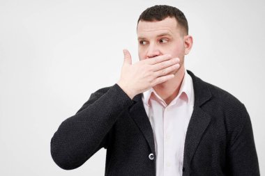 Elleriyle ağzını kapatmış, afallamış ve nutku tutulmuş bir insan portresi.