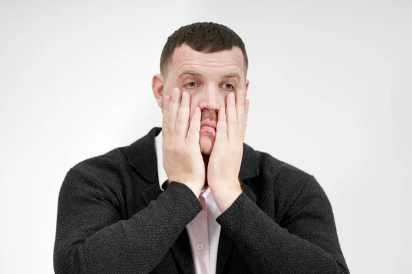 Стрессовый бизнесмен с руками на лице на сером фоне с копировальным пространством, грустью и разочарованной концепцией — стоковое фото