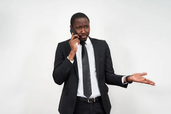 Fechar-se de irritado jovem africano gritando enquanto falava no smartphone sobre fundo cinza — Fotografia de Stock