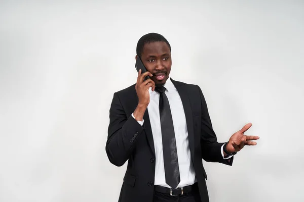 Närbild av arg ung afrikansk man skriker när man talar på smartphone över grå bakgrund — Stockfoto