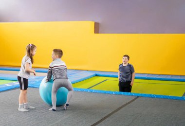 Eğlence merkezinde trambolinde zıplayan mutlu, küçük çocuklar.