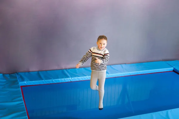 Feliz sonrisa niños pequeños saltando en el interior trampolín en el centro de entretenimiento —  Fotos de Stock