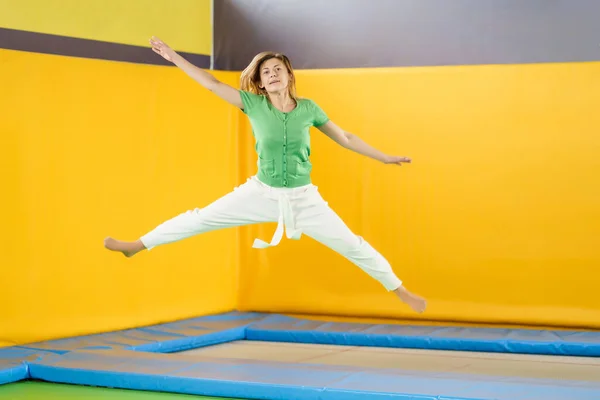 Jong meisje springen op een trampoline in sport centrum — Stockfoto