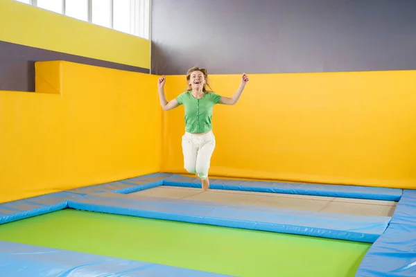 Mujer joven saltando y rebotando en un trampolín en el centro deportivo — Foto de Stock