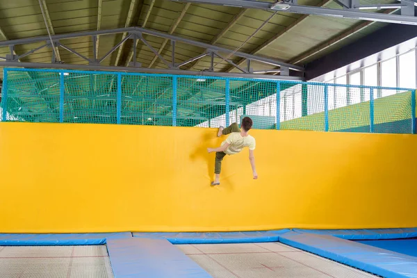 Adolescent garçon saut sur trampoline parc dans sport centre — Photo
