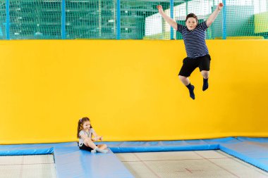 Eğlence merkezinde trambolinde zıplayan mutlu, küçük çocuklar.