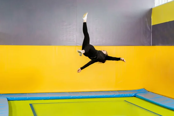 젊은 여자 아마추어 곡예 선수 점프 하 고 현대 취미와 체력 개념에 트램 폴 린, 실내 운동 — 스톡 사진