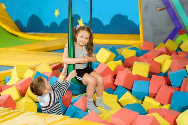 Children playing with soft cubes in the dry pool in play center. playground with foam blocks in trampoline club — Stock Photo, Image