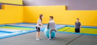 Eğlence merkezinde trambolinde zıplayan mutlu, küçük çocuklar.