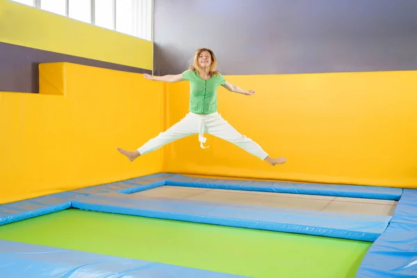 Mladá dívka skákání na trampolíně ve sportovním centru — Stock fotografie