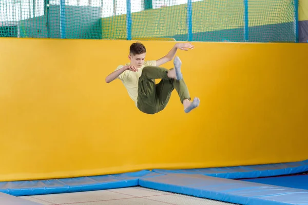 Nastolatek chłopiec skoków na trampolinie park w centrum sportu — Zdjęcie stockowe
