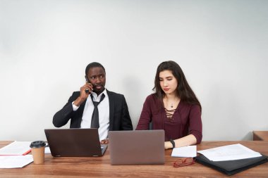 Modern ofiste birlikte çalışan genç ve mutlu iş adamları, çok ırklı takım çalışması. Akıllı telefondan arayan adam.