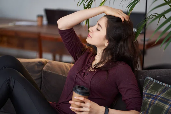 Bom fim de semana. Menina asiática relaxante, beber café e sentado em um sofá — Fotografia de Stock