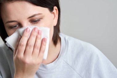 Koronavirüsten korumak için tıbbi maske yerine gazlı bez ya da bandaj tutan genç bir kadın. Maske konsepti eksikliği