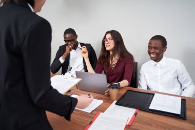 Modern ofiste birlikte çalışan genç ve mutlu iş adamları, çok ırklı takım çalışması.